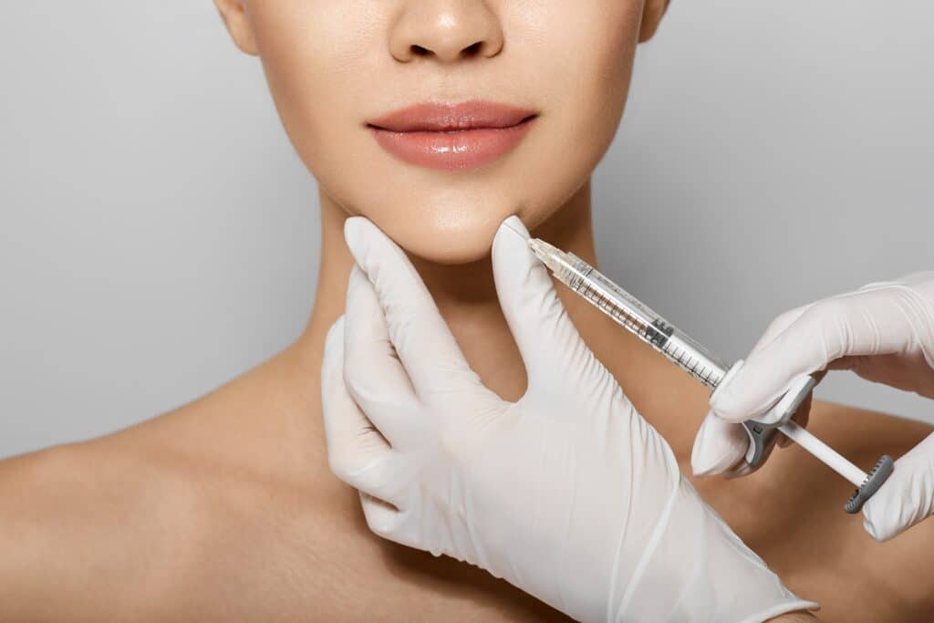 Syringe Near Woman's Chin Beauty Injections With Fillers